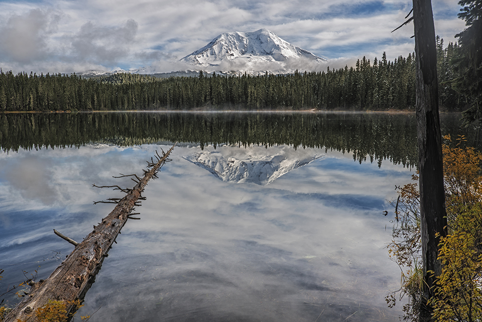 "Takhlakh Lake with Mount Adams" by Loree Johnson Photography. This image is part of the artist's specially selected Premium Collection of distinctive images. As the remains of an autumn snowstorm slowly clear, majestic Mount Adams, wearing a fresh blanket of snow, is unveiled by the retreating clouds. The gorgeous, mirror-like reflection in Takhlakh Lake, would seem unreal if not for the mist rising from the far shore.